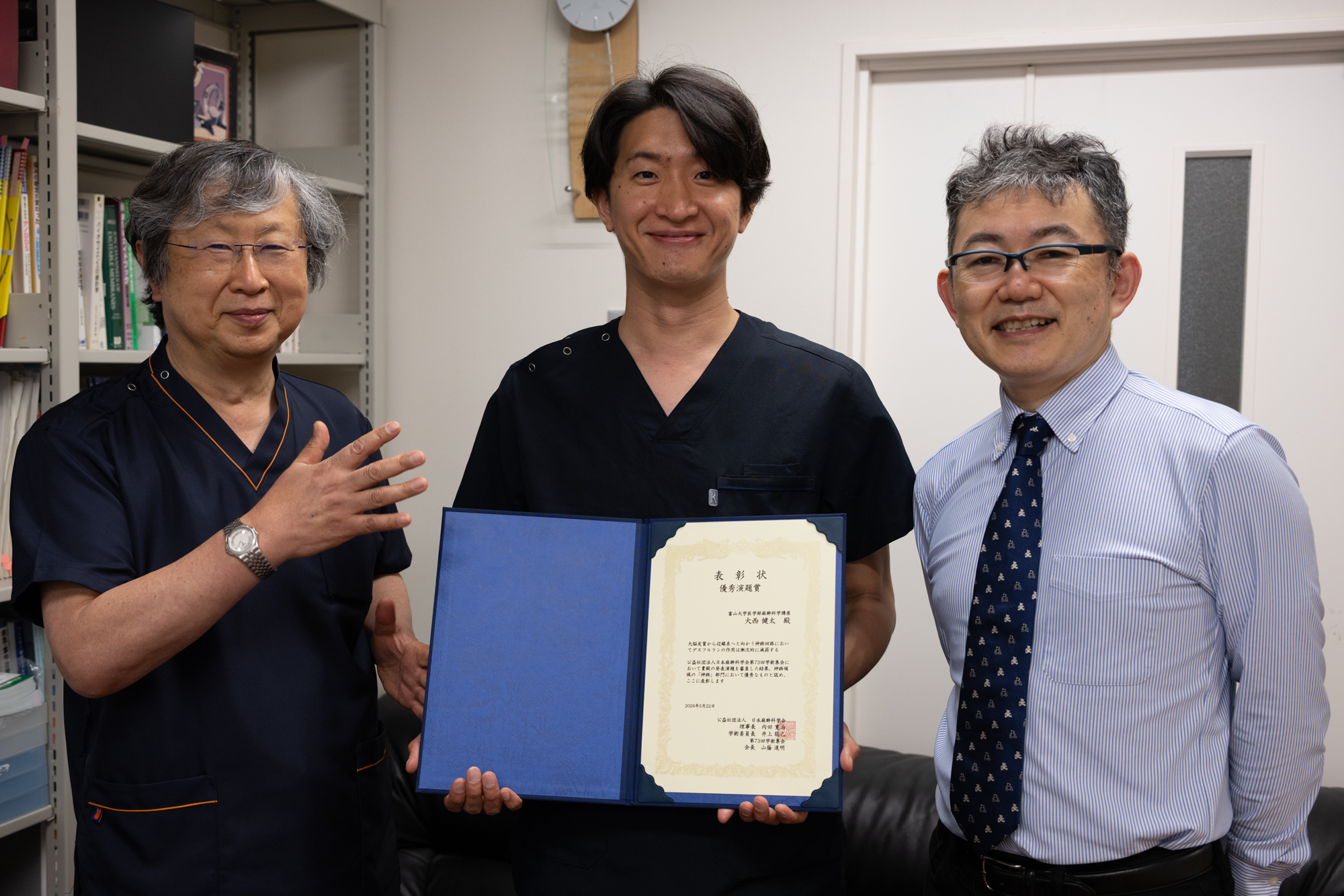 3人で表彰状を持つ写真